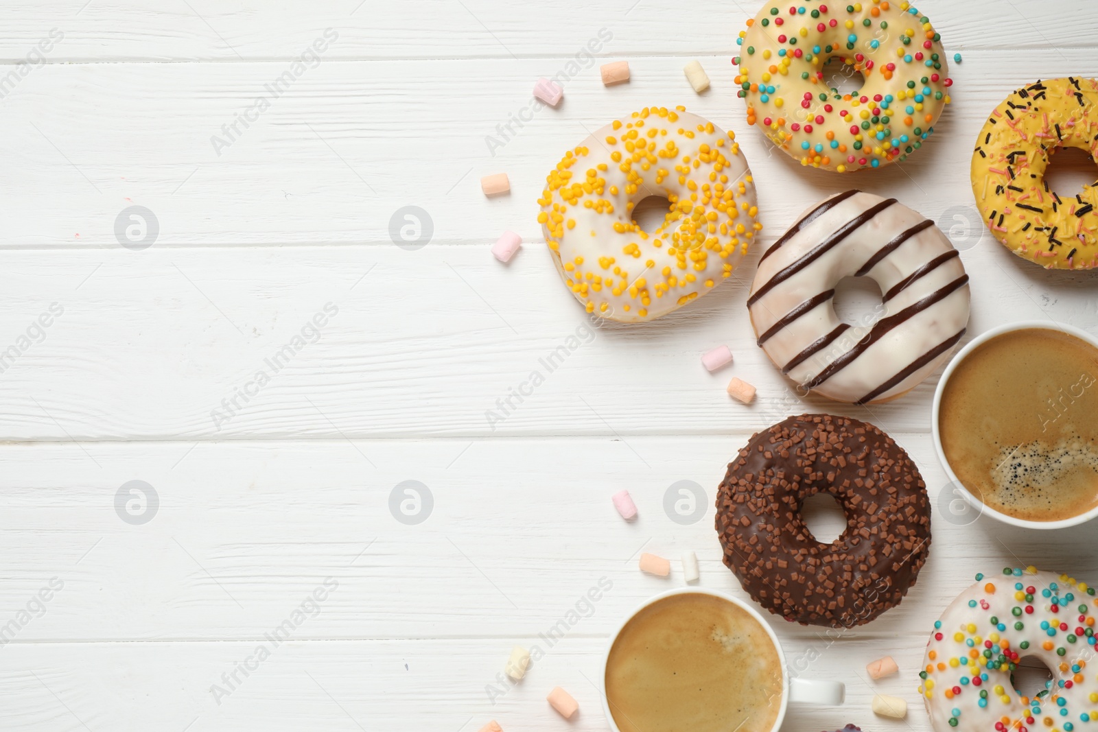 Photo of Flat lay composition with yummy donuts on white wooden background, space for text