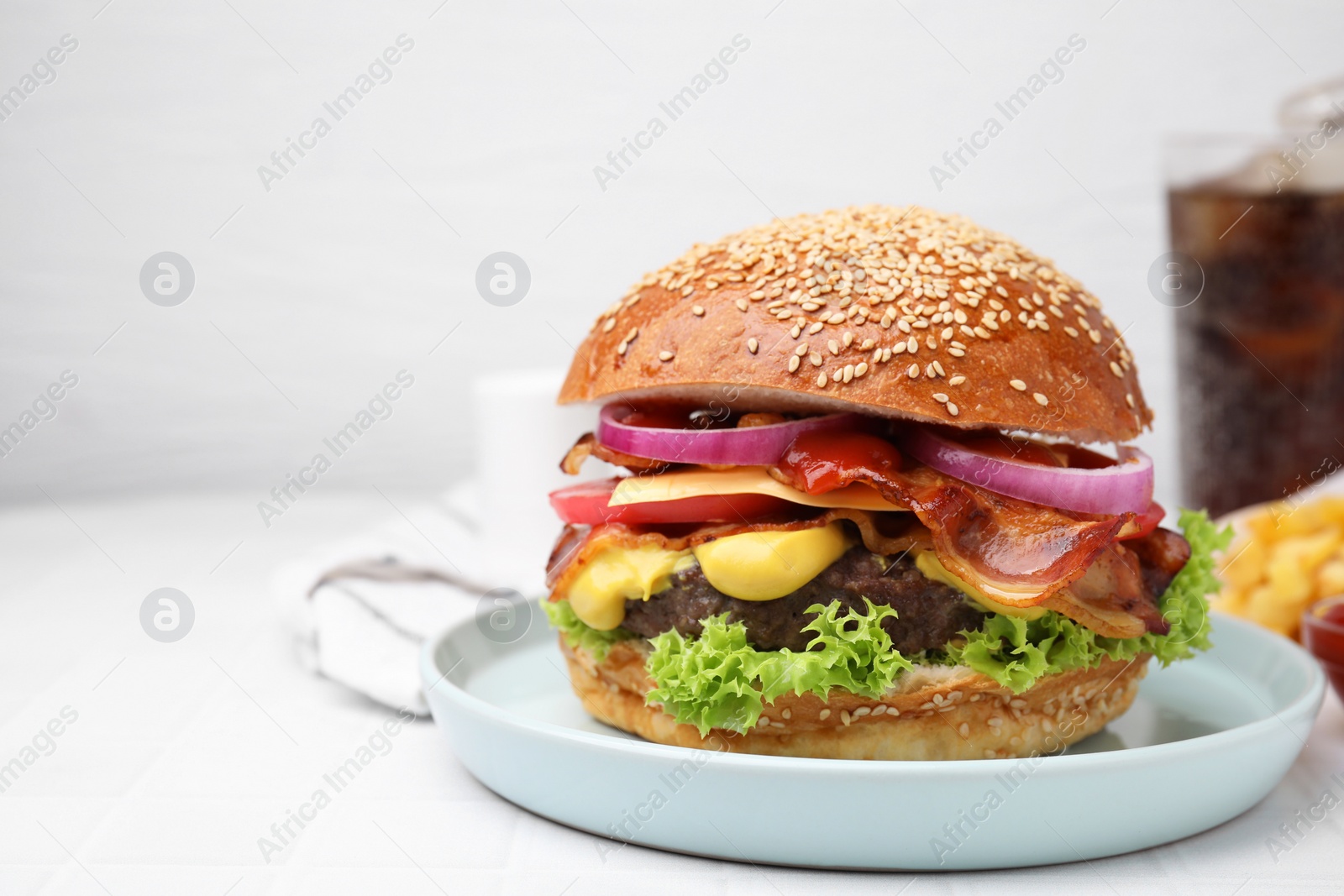 Photo of Delicious burger with bacon, patty and vegetables on white tiled table, space for text