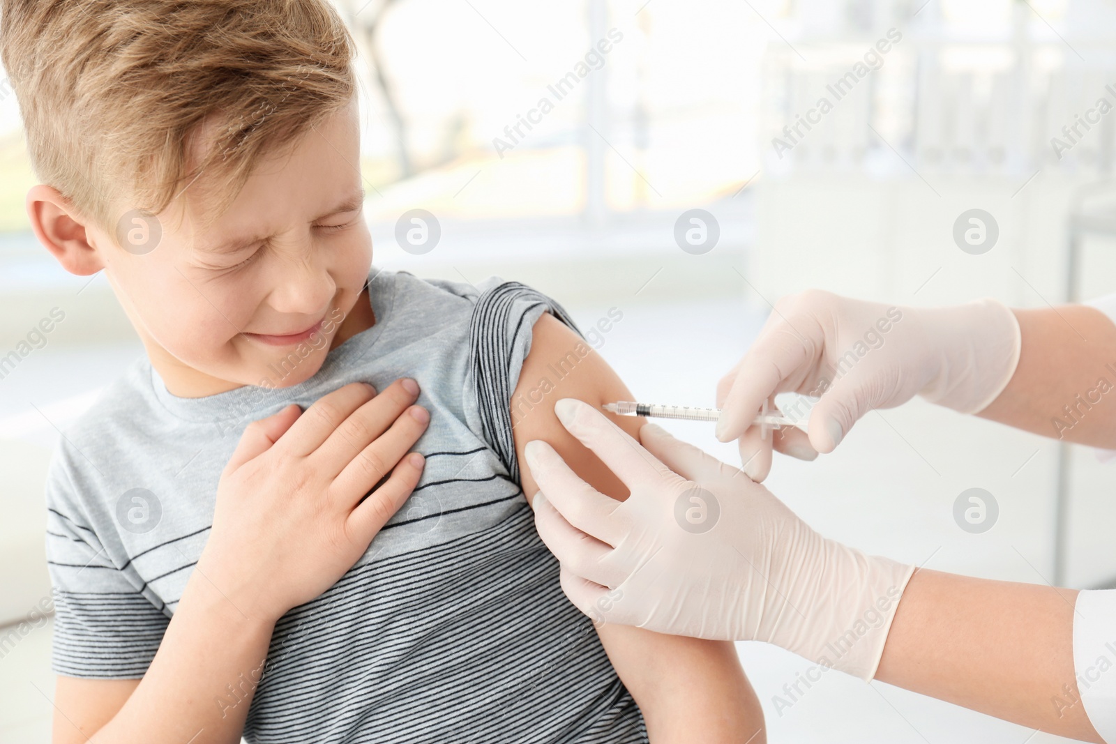 Photo of Doctor vaccinating little boy in hospital