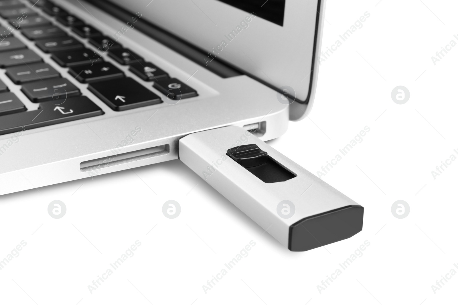 Photo of Modern usb flash drive attached into laptop on white background, closeup