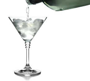 Pouring vermouth into glass with ice cubes for martini cocktail on white background