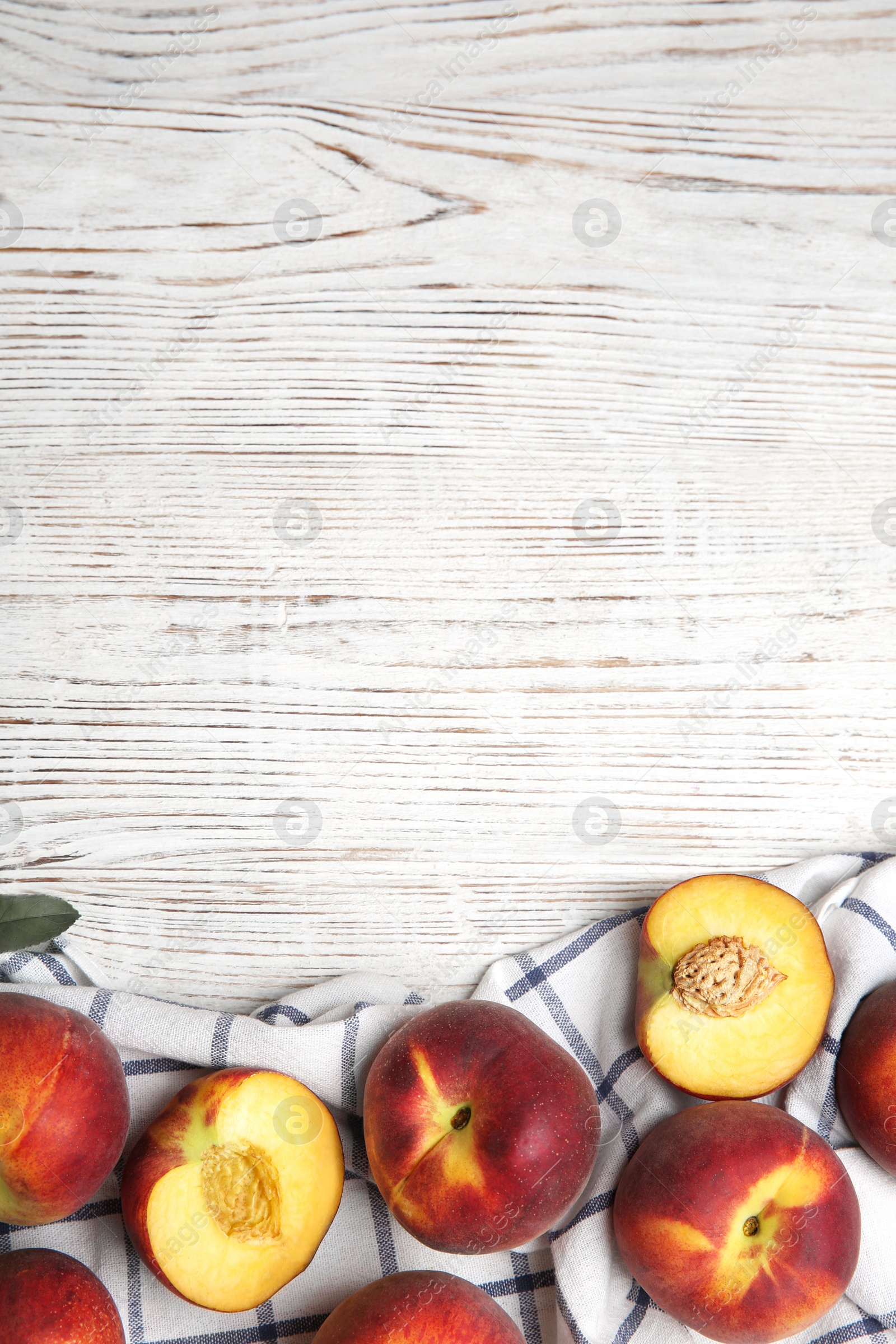 Photo of Tasty fresh peaches and fabric on white wooden table, flat lay. Space for text