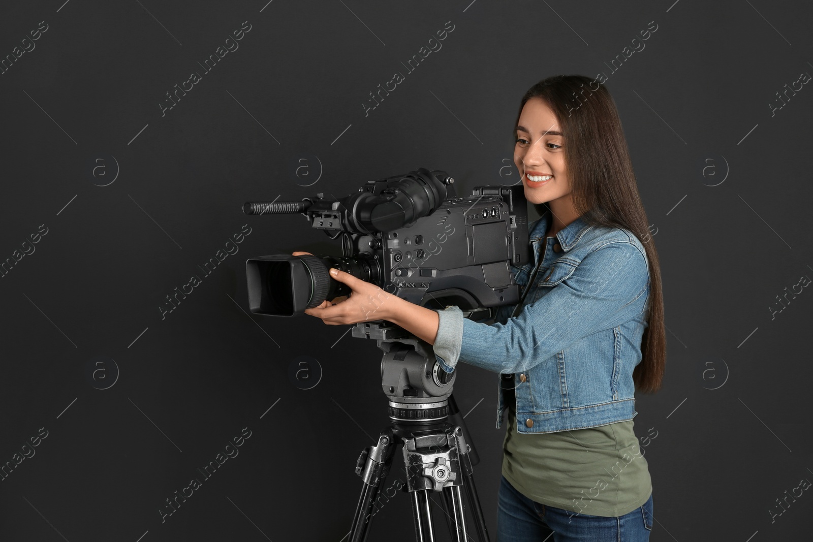 Photo of Operator with professional video camera on black background