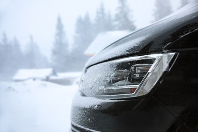 Modern car covered in snow outdoors on winter day, closeup