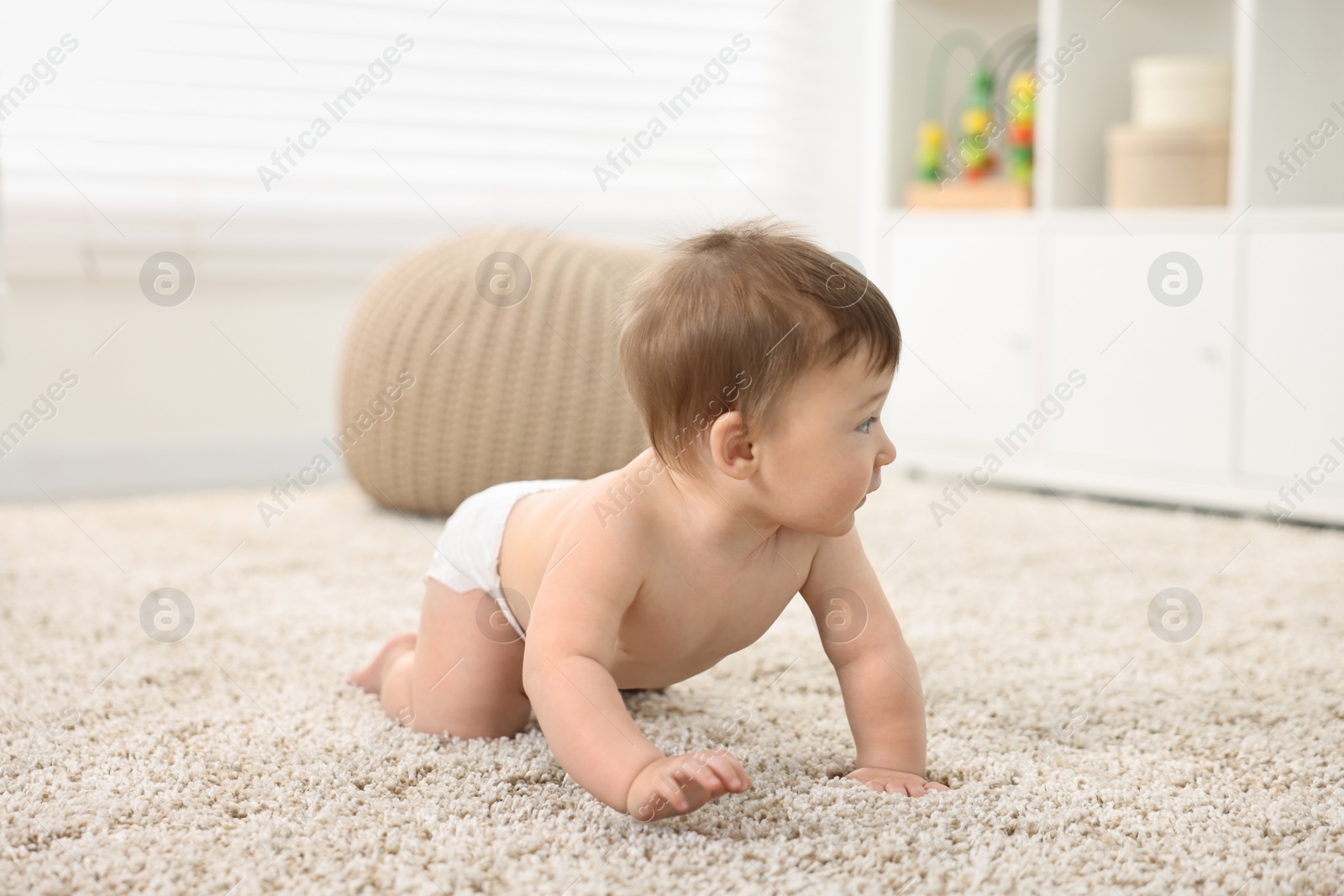 Photo of Cute baby boy crawling on carpet at home