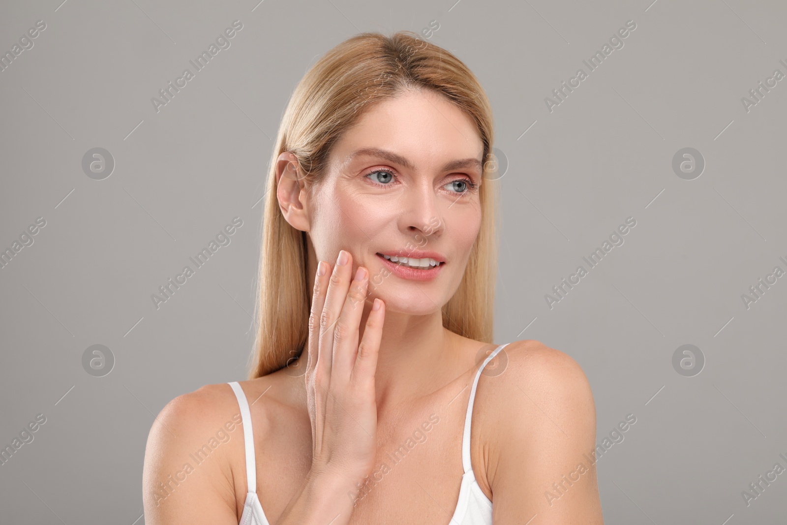 Photo of Beautiful woman with healthy skin on gray background