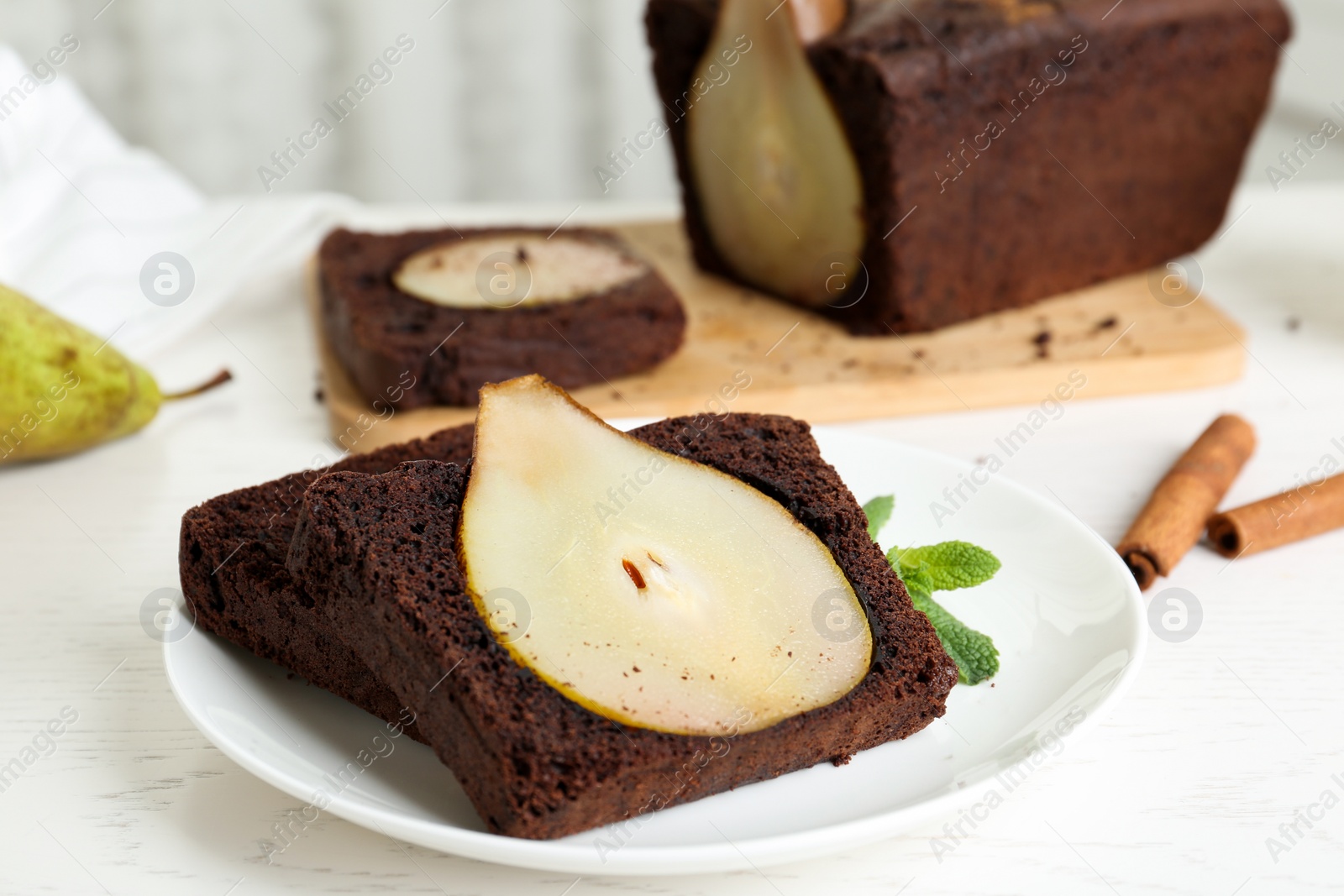 Photo of Tasty pear bread served with mint on white wooden table. Homemade cake