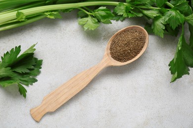 Photo of Spoon of celery seeds and fresh plant on light grey textured table, flat lay