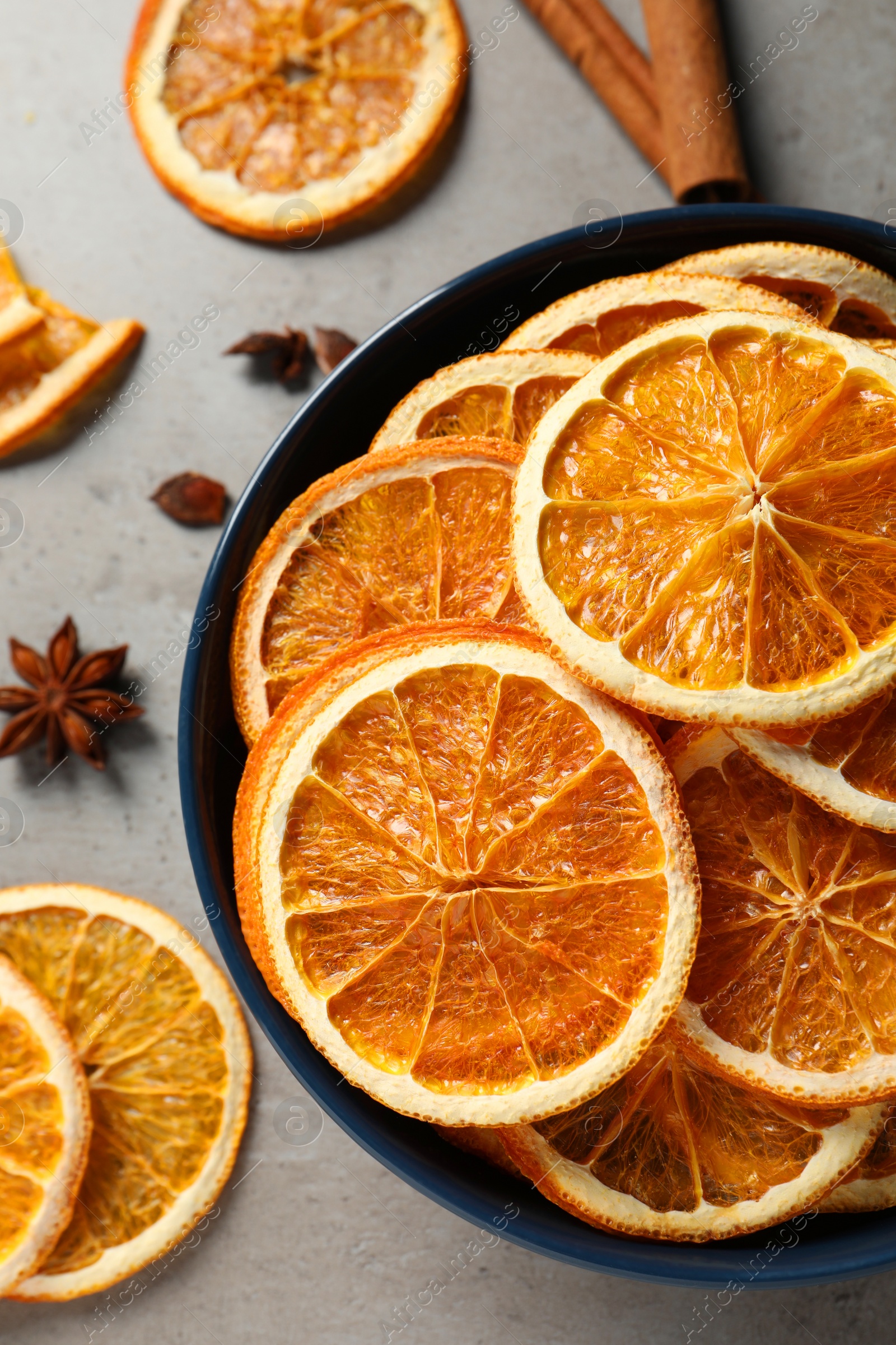 Photo of Dry orange slices and anise stars on grey table, flat lay