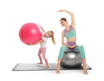 Young woman and her daughter doing exercise isolated on white. Home fitness