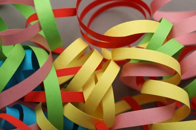 Colorful serpentine streamers on grey background, closeup