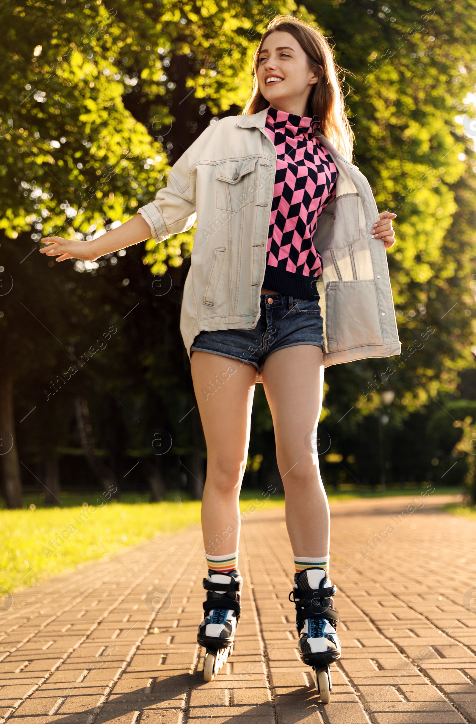 Photo of Beautiful young woman with roller skates having fun outdoors