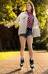 Beautiful young woman with roller skates having fun outdoors