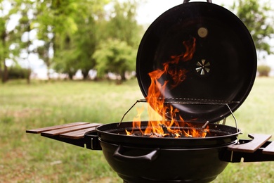 Photo of Modern barbecue grill with fire flames outdoors