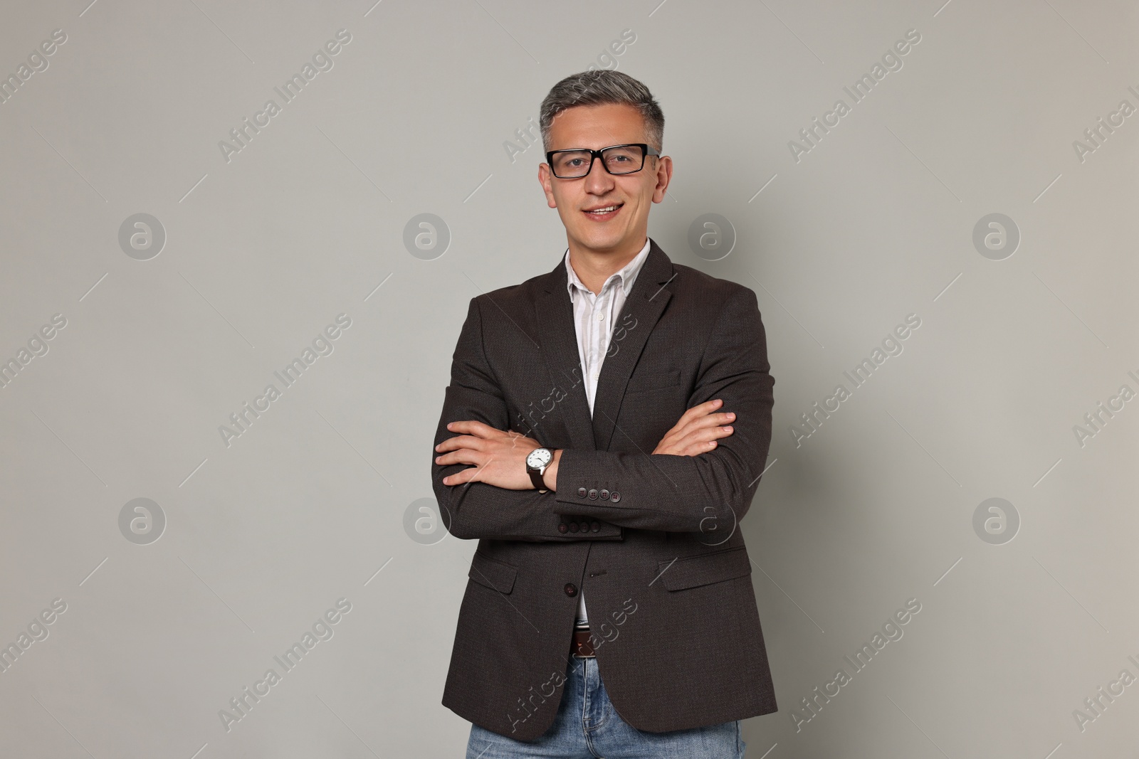 Photo of Happy man in glasses on grey background