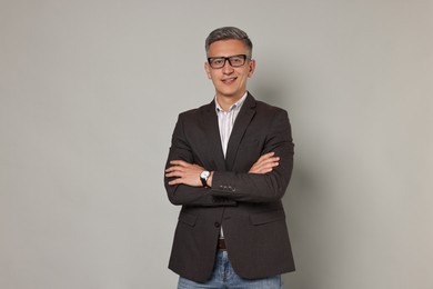 Happy man in glasses on grey background