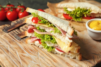 Photo of Tasty toast sandwich on wooden board. Wheat bread