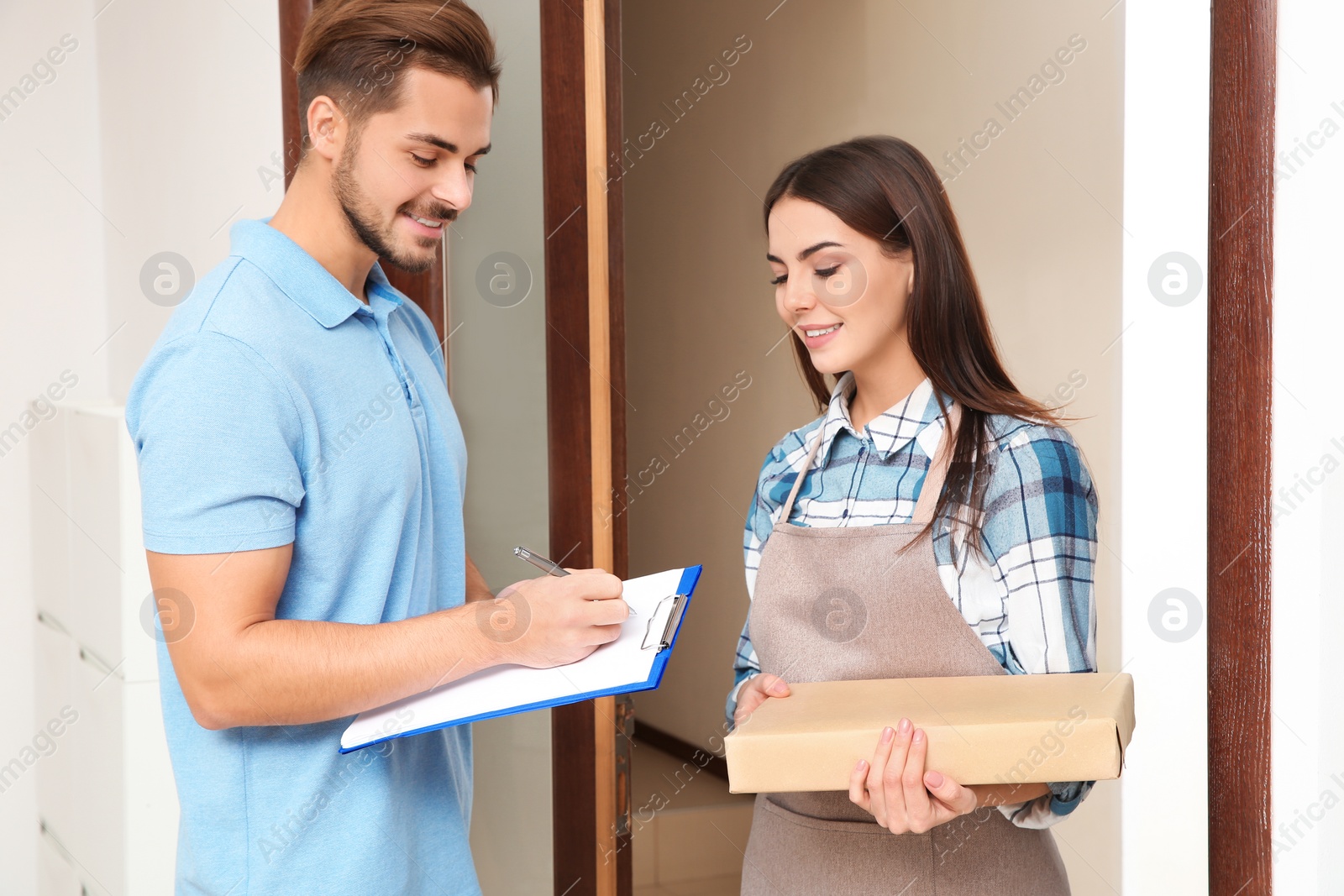 Photo of Client receiving parcels from delivery service courier indoors
