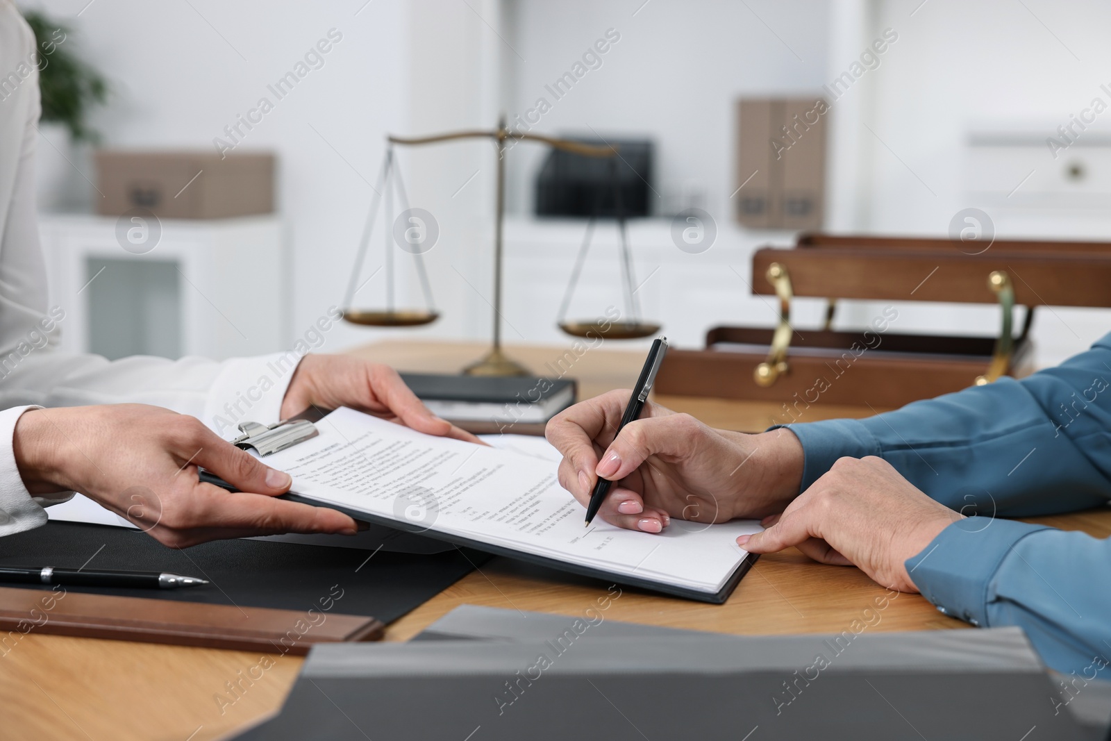 Photo of Senior woman signing document in lawyer's office, closeup