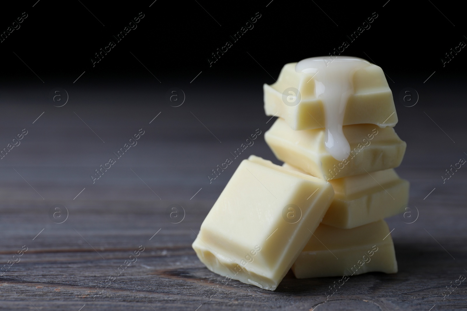 Photo of Delicious white chocolate with syrup on wooden table, closeup. Space for text