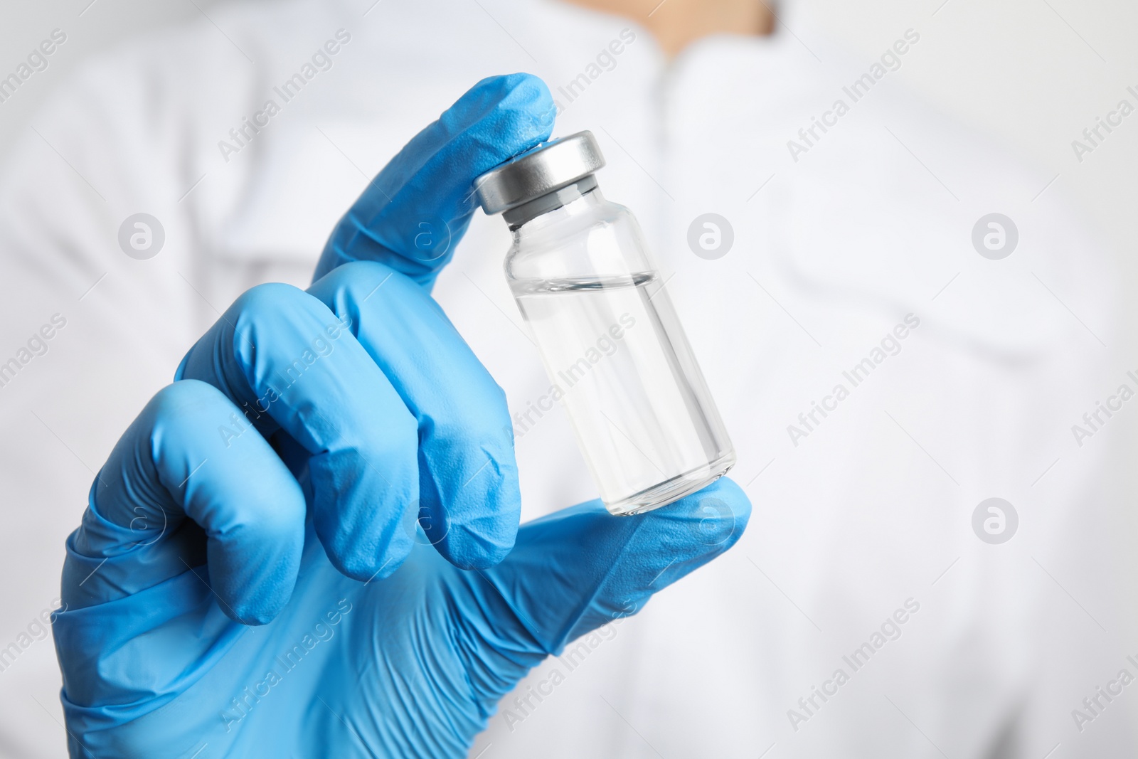 Photo of Doctor holding vial with medication, closeup. Vaccination and immunization