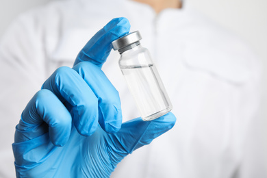 Doctor holding vial with medication, closeup. Vaccination and immunization