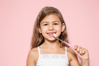 Photo of Portrait of little girl with toothbrush on color background