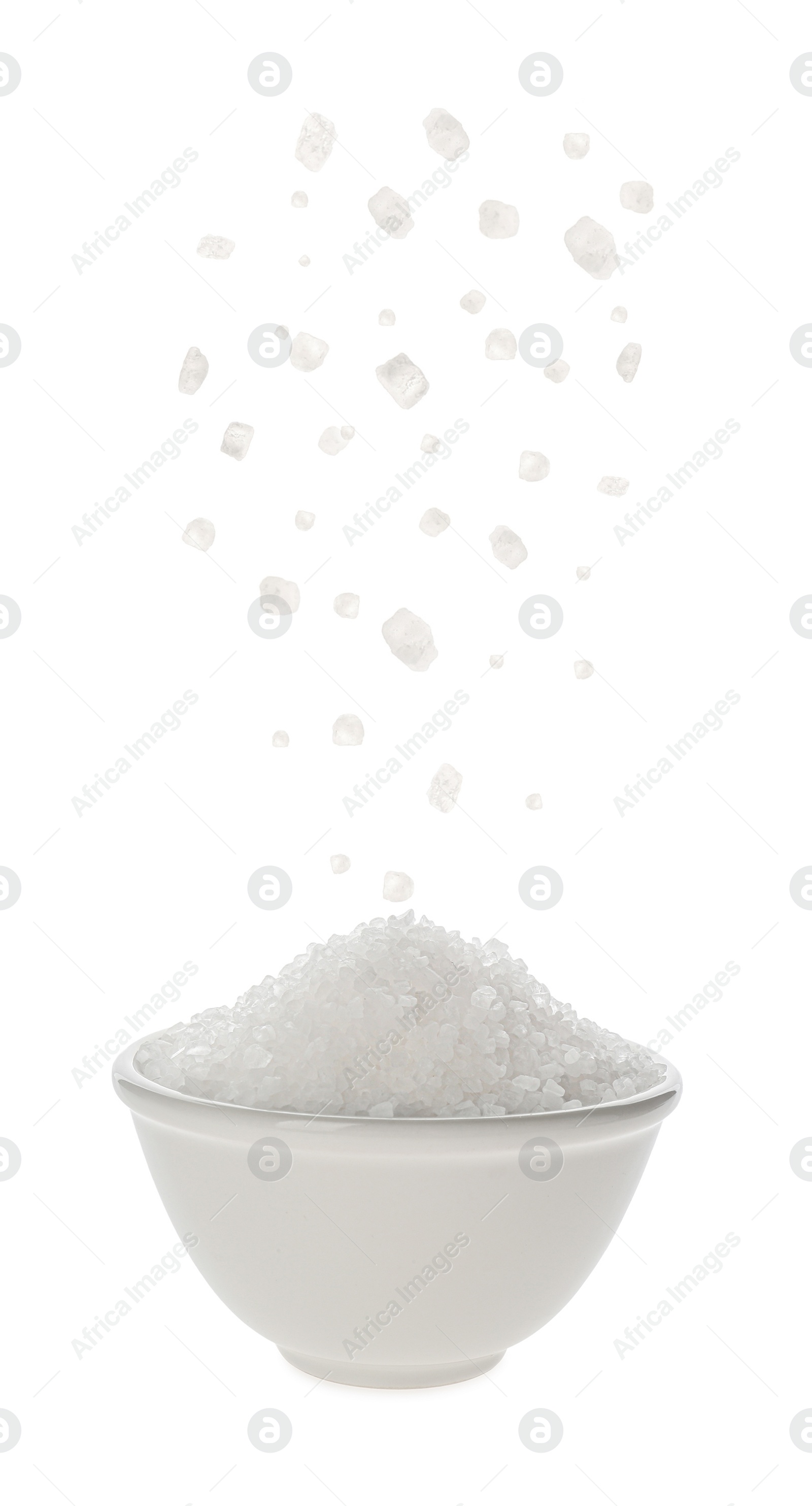 Image of Salt falling into bowl on white background