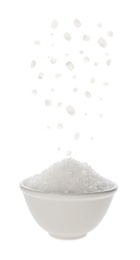 Image of Salt falling into bowl on white background