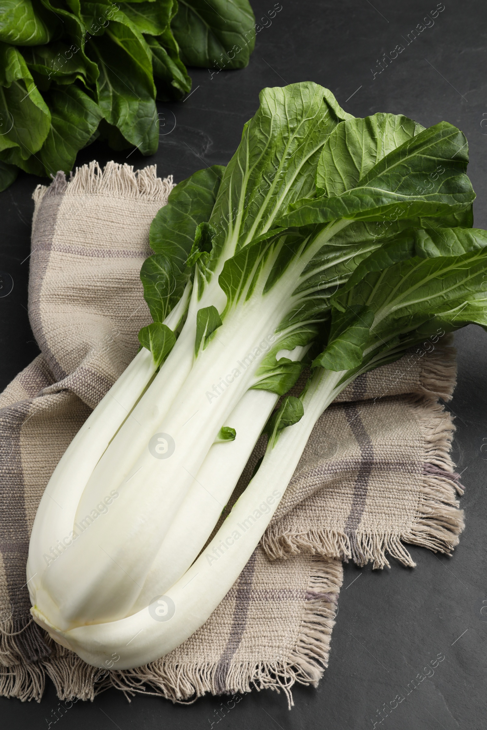 Photo of Fresh green pak choy cabbage on black table, above view