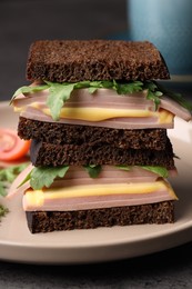 Photo of Delicious sandwiches with boiled sausage, cheese and arugula on table, closeup