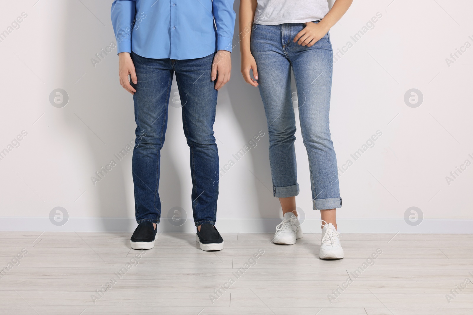 Photo of People in stylish jeans near white wall indoors, closeup