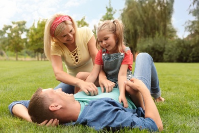 Happy family spending time together in park on green grass