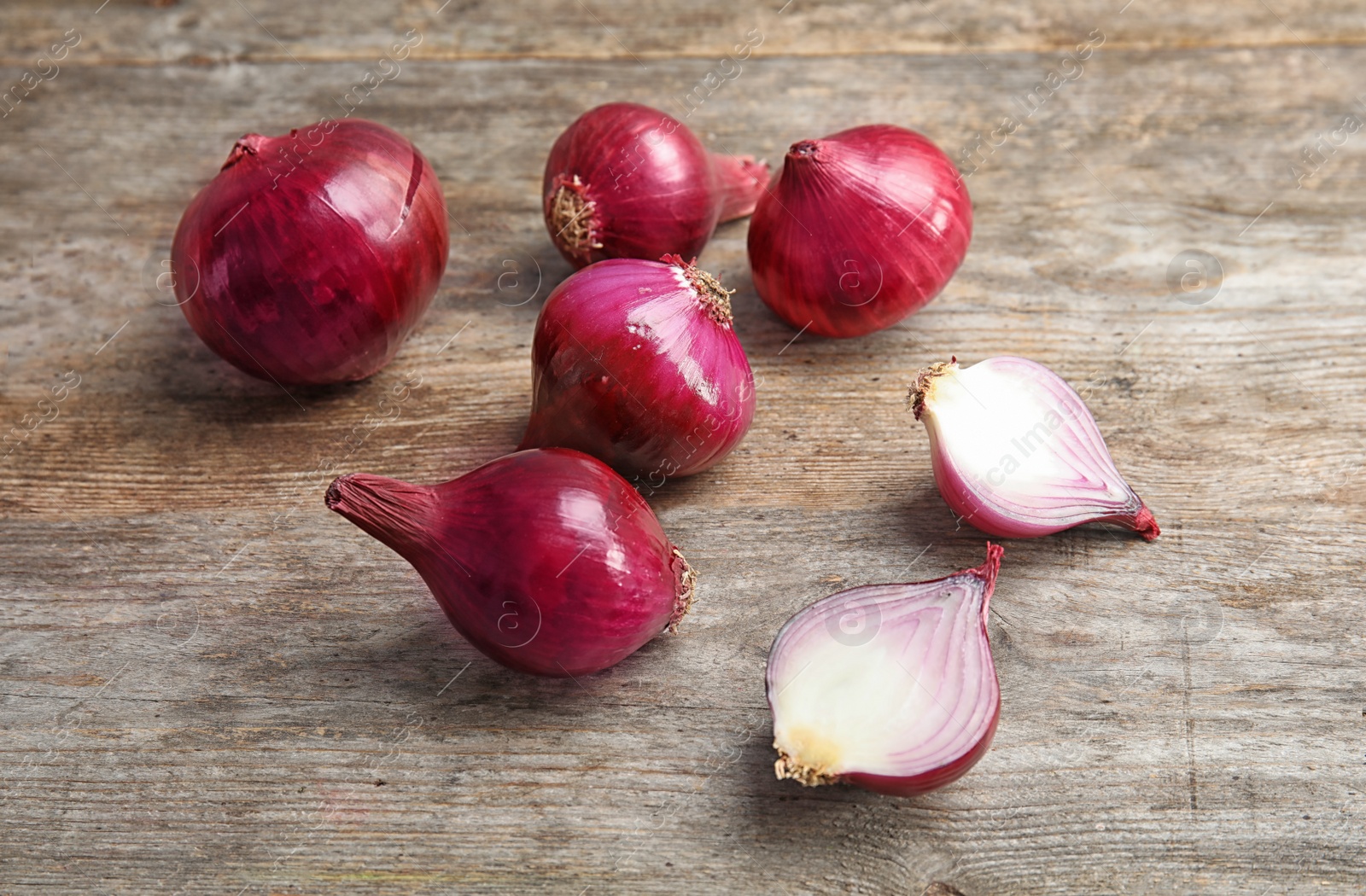 Photo of Ripe red onions on wooden table