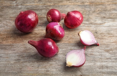 Photo of Ripe red onions on wooden table