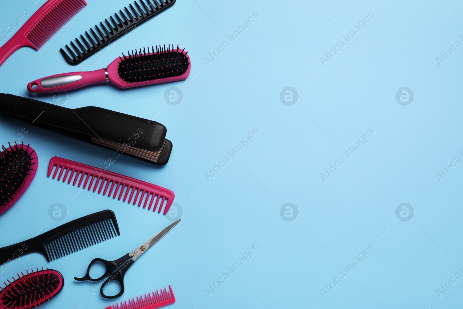 Photo of Flat lay composition of professional hairdresser tools on light blue background, space for text