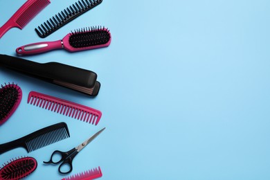 Photo of Flat lay composition of professional hairdresser tools on light blue background, space for text