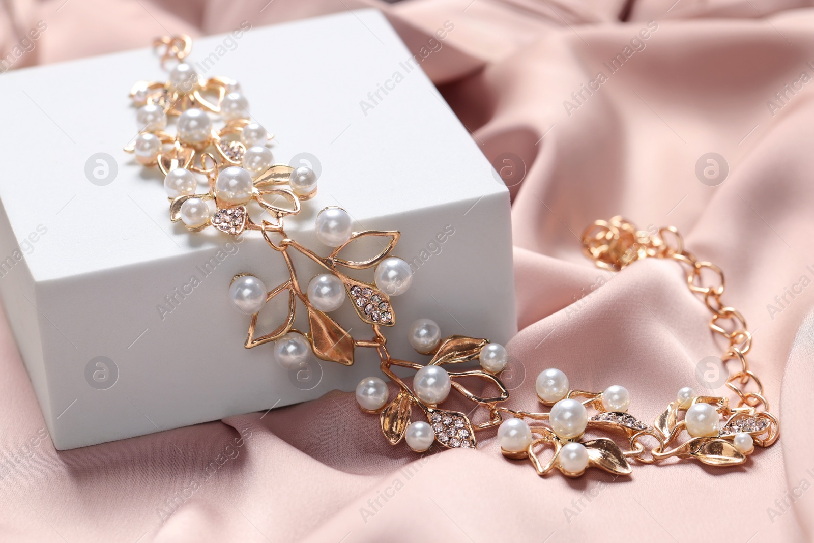 Photo of Beautiful necklace on beige fabric. Luxury jewelry