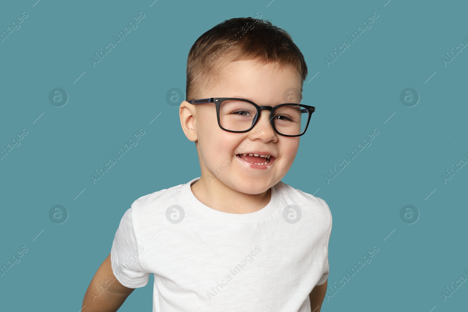 Photo of Cute little boy in glasses on light blue background