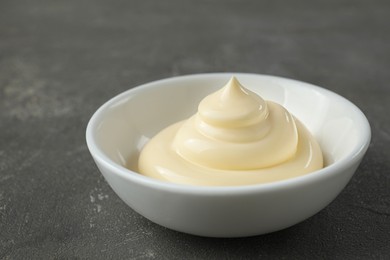 Photo of Fresh mayonnaise sauce in bowl on grey table, closeup