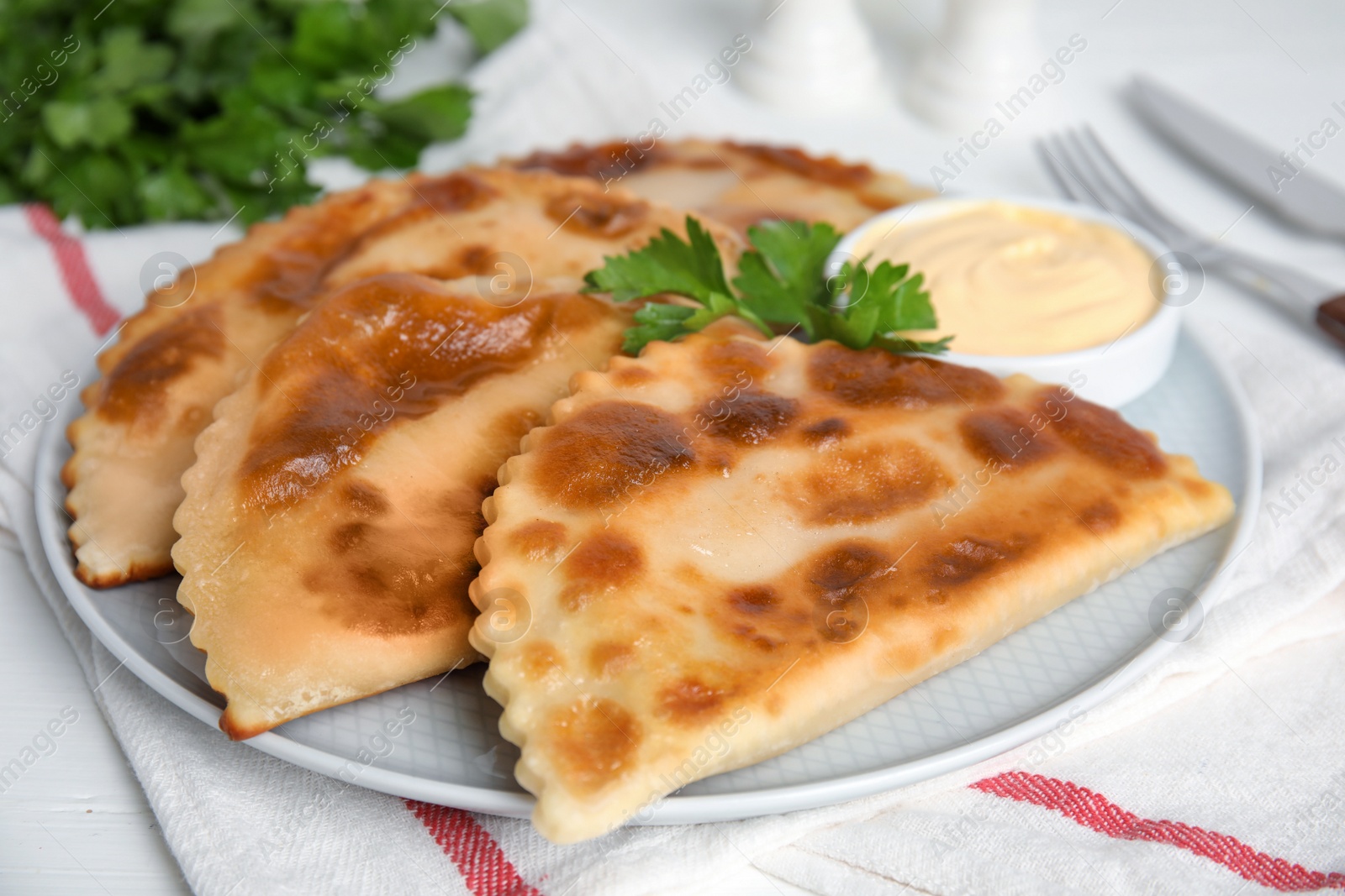 Photo of Delicious fried chebureki served on white table, closeup