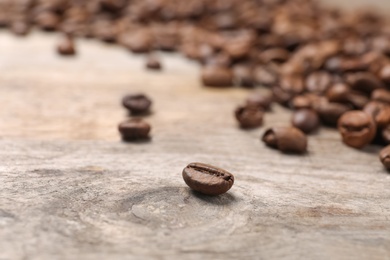 Photo of Coffee beans on wooden table, closeup