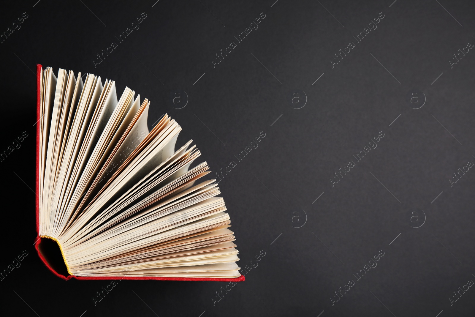 Photo of Hardcover book on black background, top view. Space for text