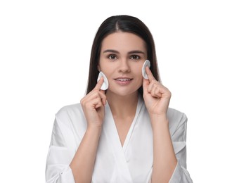Photo of Young woman cleaning her face with cotton pads on white background