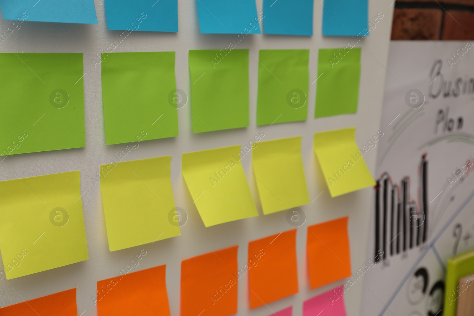 Photo of Blank colorful paper notes on white board, closeup