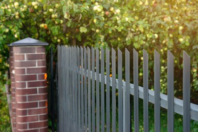 Photo of Beautiful brick fence with iron railing outdoors