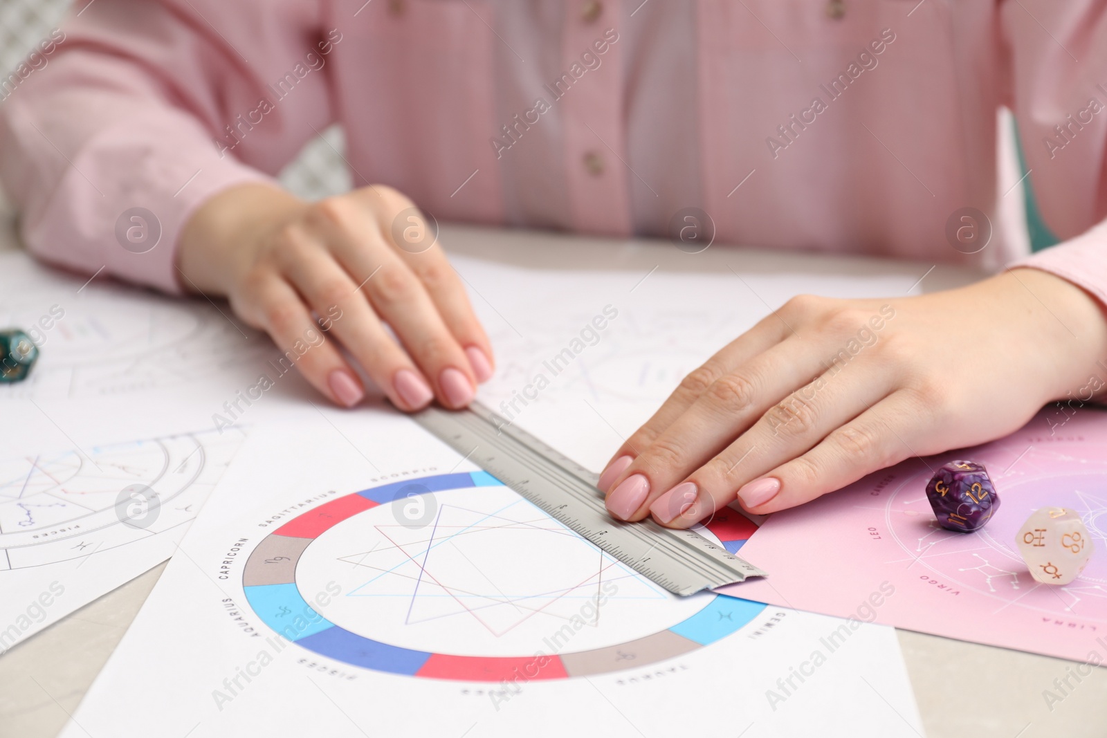 Photo of Astrologer using zodiac wheel for fate forecast at table, closeup. Fortune telling