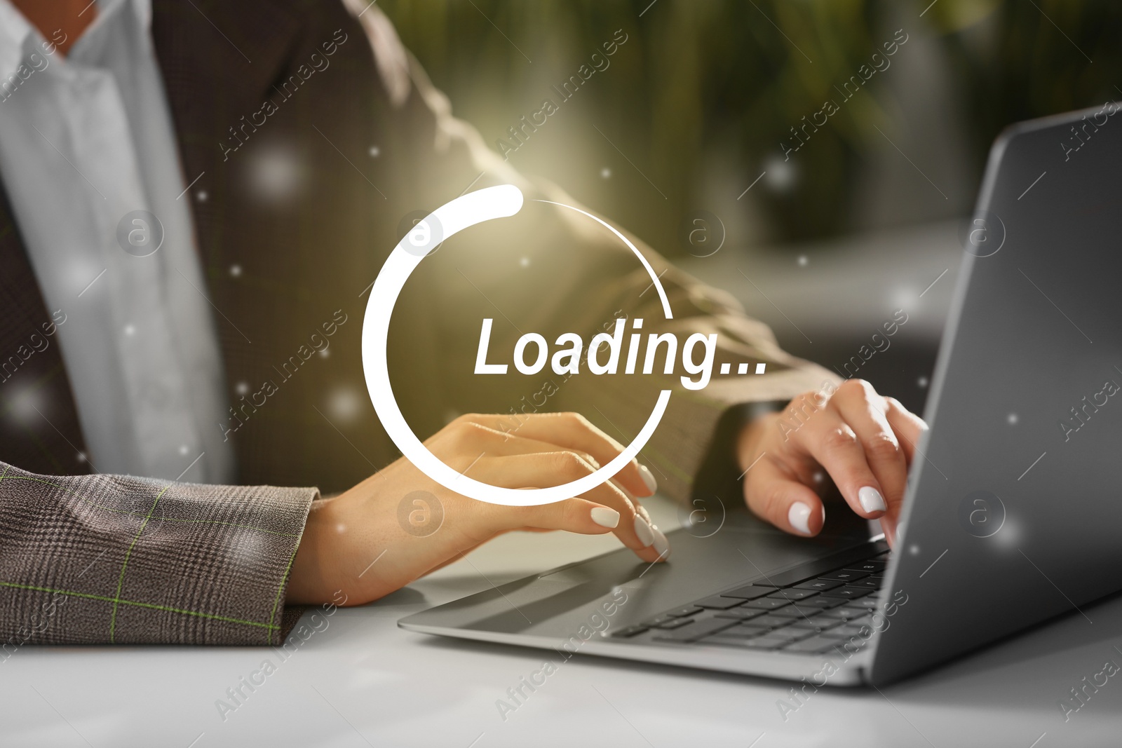 Image of Loading. Woman working on laptop at table indoors, closeup