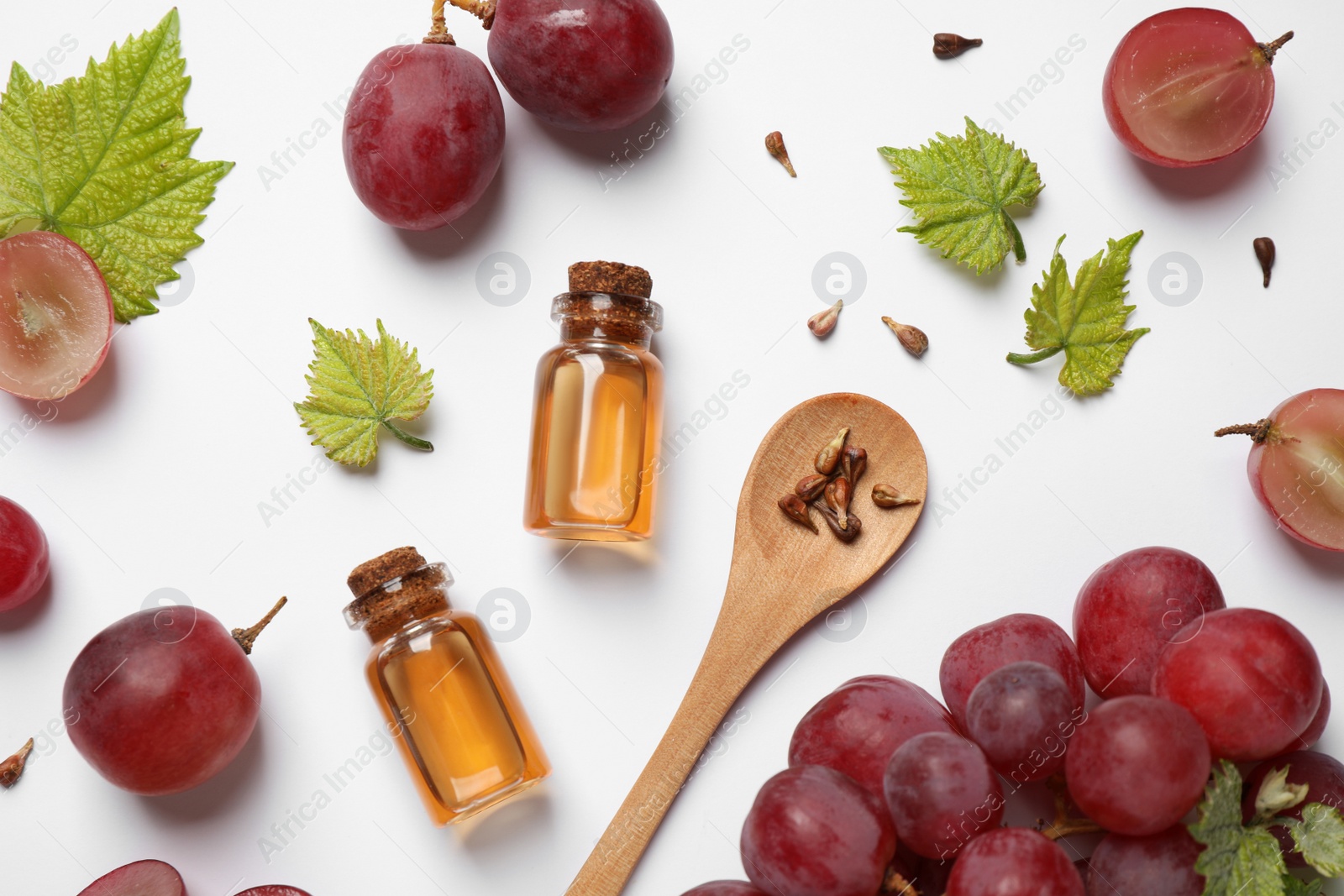 Photo of Composition with bottles of natural grape seed oil on white background, top view. Organic cosmetic