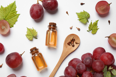 Photo of Composition with bottles of natural grape seed oil on white background, top view. Organic cosmetic